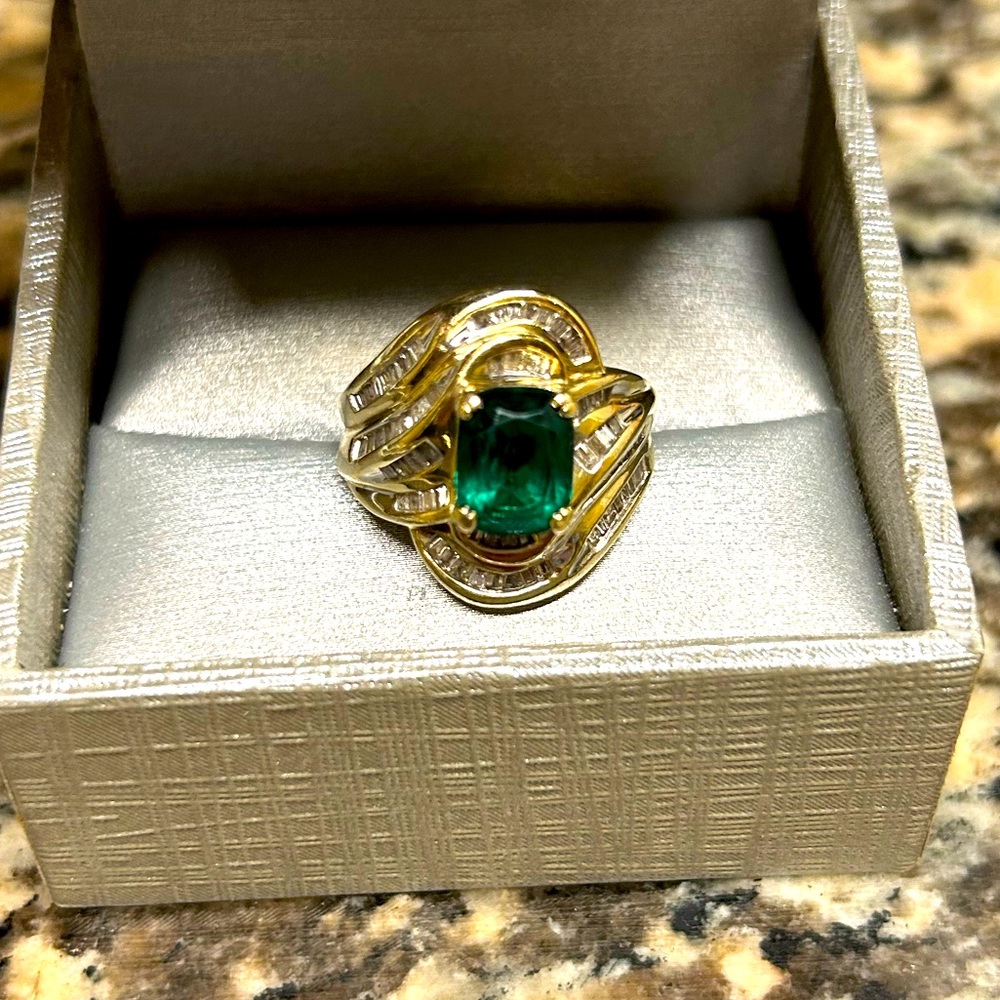 Beautiful emerald center stone, Diamond baguettes set in 10k yellow gold.